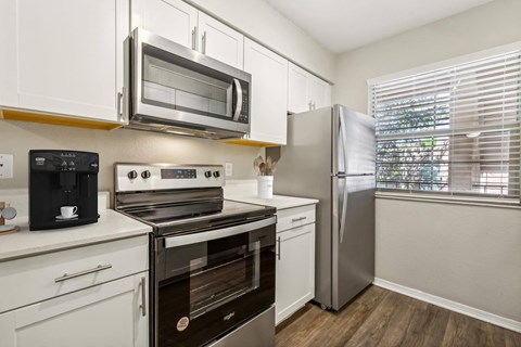 a kitchen with stainless steel appliances and white cabinets at Acacia Gardens, Albuquerque, NM, 87111